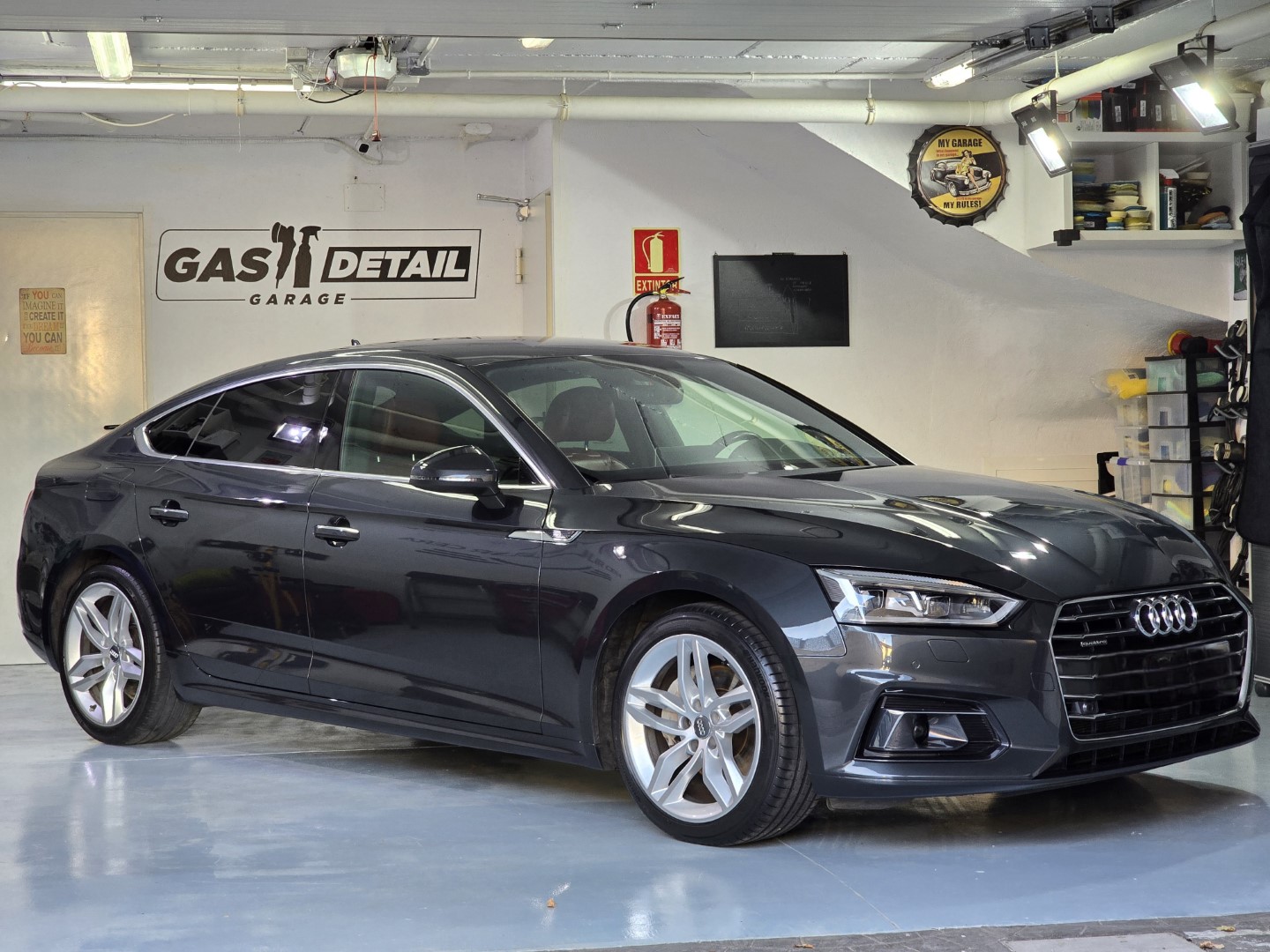 Coche Audi negro en un taller de detalle.