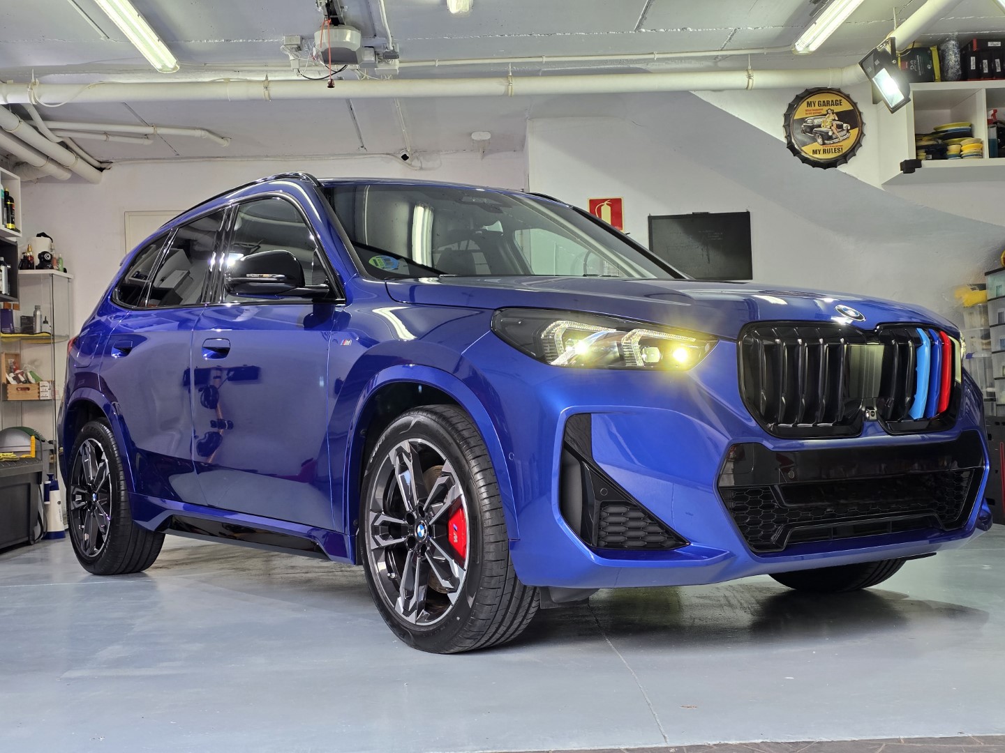 Coche azul deportivo en garaje iluminado