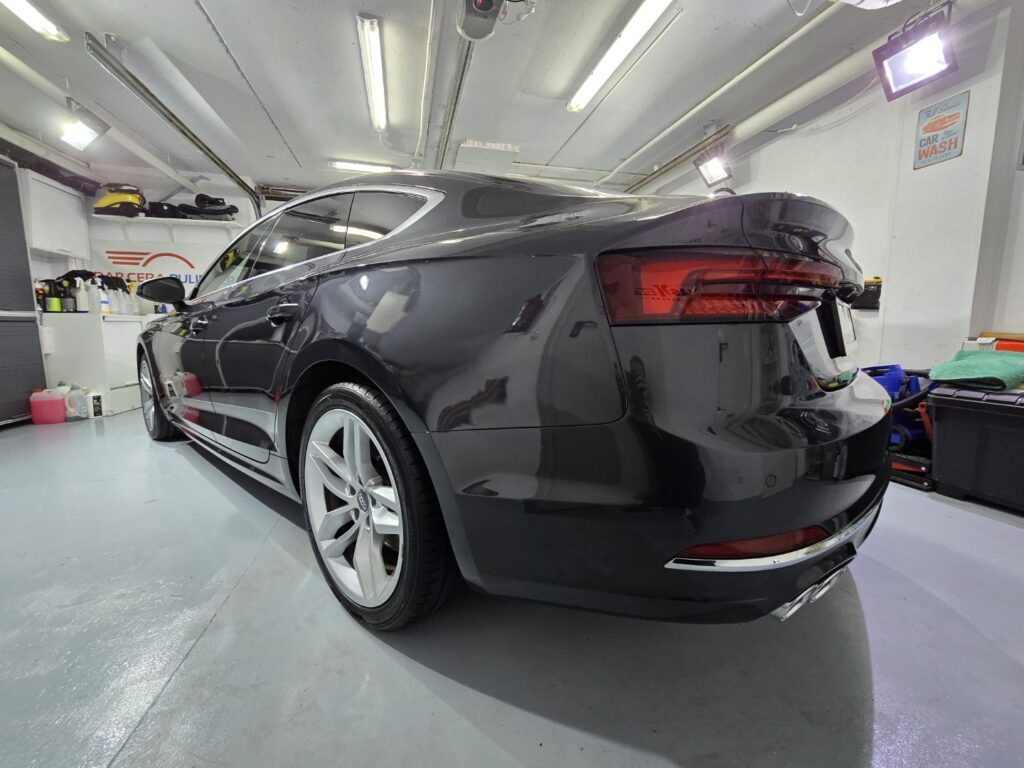 Coche negro brillante en garaje iluminado