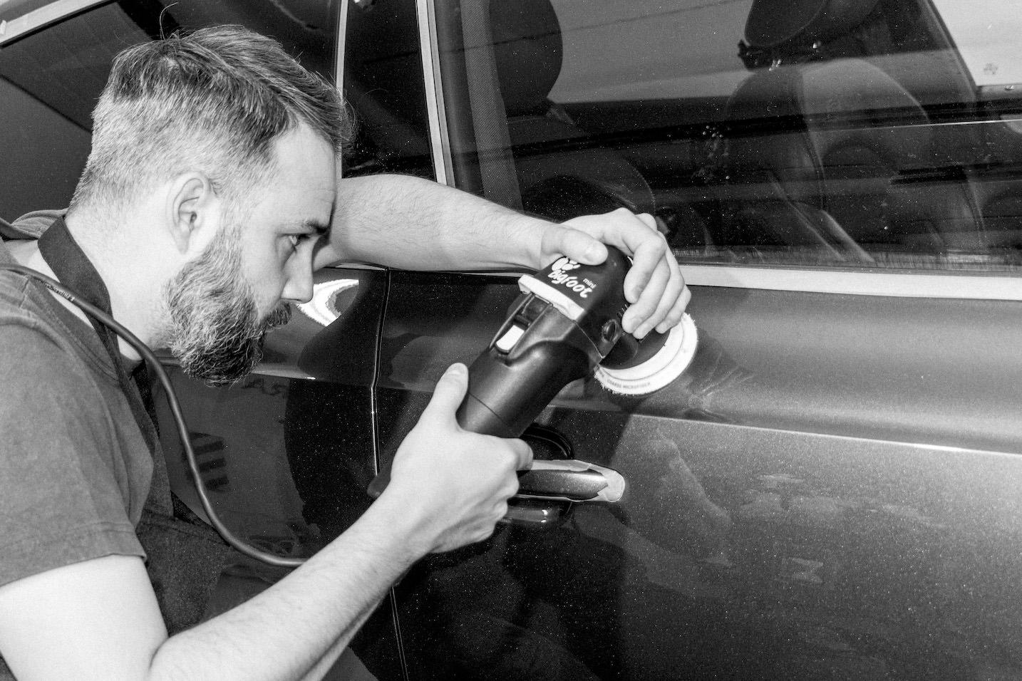 Hombre puliendo puerta de coche