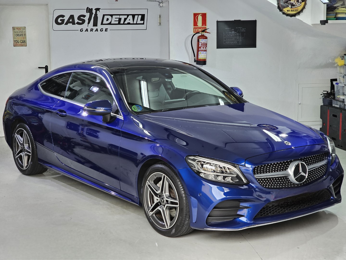 Coche azul en taller de lavado detallado