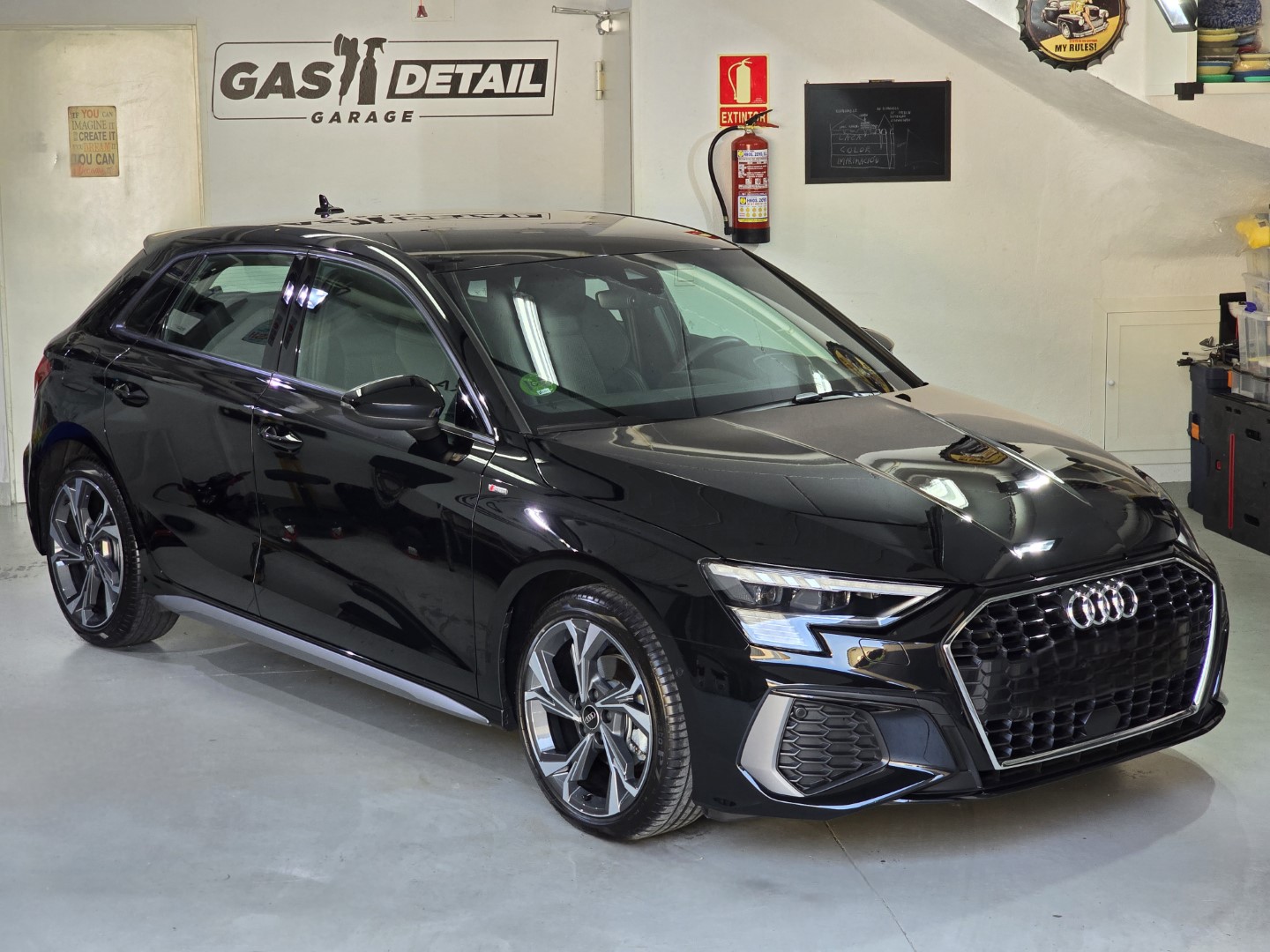 Coche negro en taller de detalles automotrices